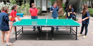 mesa de ping pong en instituto con estudiantes jugando
