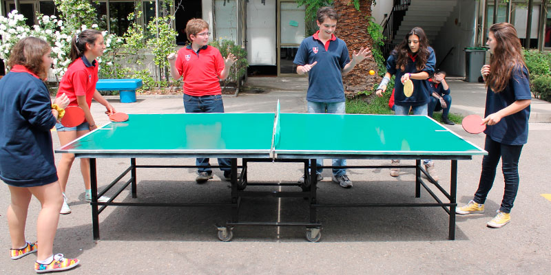 mesa de ping pong en instituto con estudiantes jugando