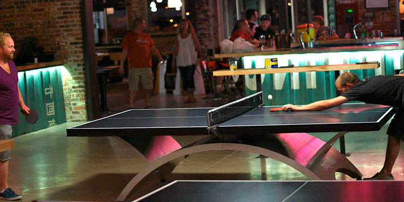 derrotado jugando al ping pong en un pub